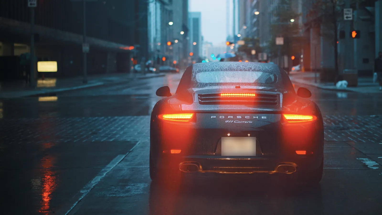 Porsche 911 sports car on a rainy city street