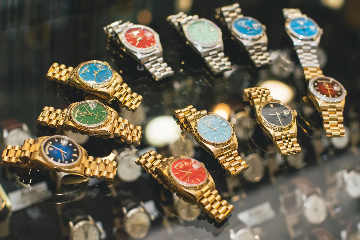 Rolex Day-Date watches with colored dials in a display case